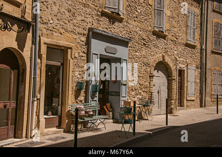 Blick auf typische Häuser aus Stein und Geschäfte auf einer Straße des historischen Dorf Lourmarin. In der Region Provence, Südfrankreich. Stockfoto