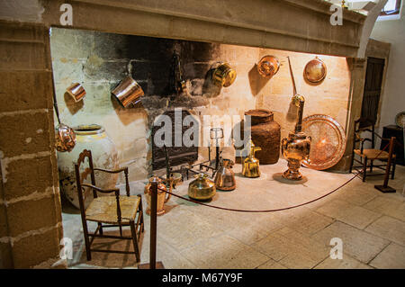 Großen Kamin mit dekorativem Kupfer Küchenutensilien und Stühlen in Lourmarin schloss. In der Region Provence, Südfrankreich. Stockfoto