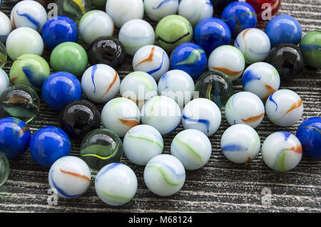 Ein Baby spielen mit Glasmurmeln, farbigem Glas Marmor, Hunderte von bunten Glasmurmeln, Stockfoto