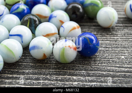 Ein Baby spielen mit Glasmurmeln, farbigem Glas Marmor, Hunderte von bunten Glasmurmeln, Stockfoto