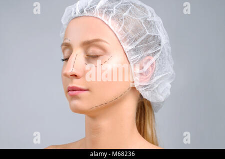 Plastische Chirurgie. Anti-aging-Behandlung und Face Lift. Frau mit Perforation Linien auf dem Gesicht. Stockfoto