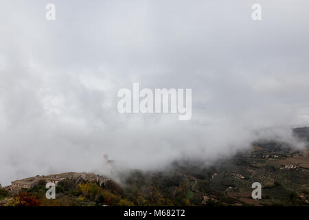 Blick auf die St. Francis päpstliche Kirche in Assisi (Umbrien, Italien) in der Mitte der Aufhebung Morgennebel Stockfoto