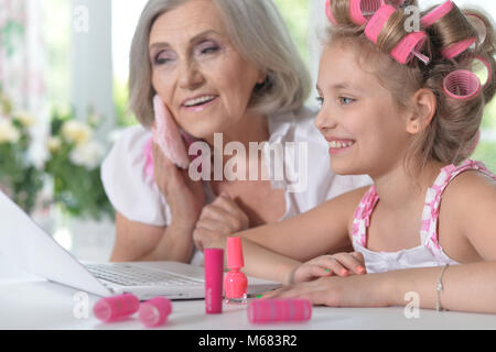 kleines Mädchen mit Oma mit laptop Stockfoto