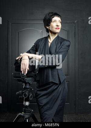 Porträt einer schönen Frau mittleren Alters mit einer Kamera Stockfoto