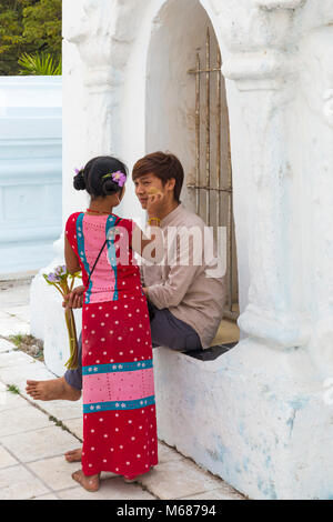 Mädchen Anwendung thanaka auf die Wange des Mannes in der Kuthodaw Pagode, Mandalay, Myanmar (Birma), Asien im Februar Stockfoto