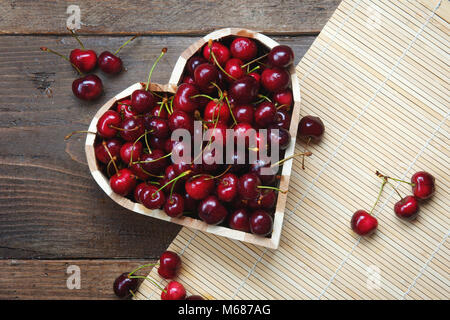 Cherry Herz - Leckere süße frische Kirschen in einen herzförmigen Houten Stockfoto