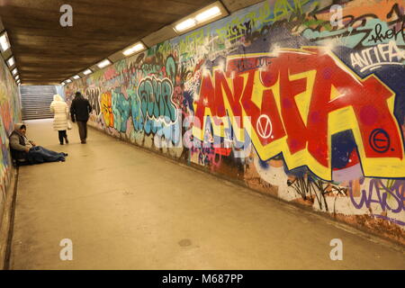 Obdachloser betteln um Geld in einem U-Bahn Tunnel in Graffiti bedeckt Stockfoto