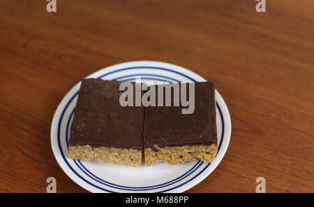 Zwei Schokolade krispy Bar Snacks auf einer Platte Stockfoto