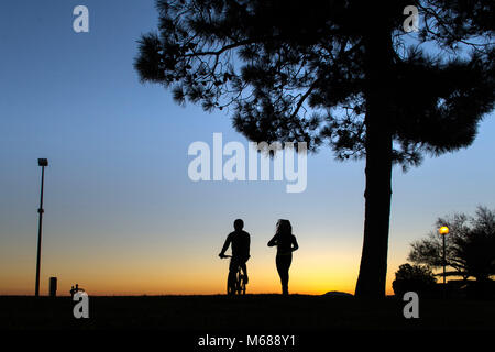 In Argeles-sur-Mer (Frankreich). Zwei junge Leute, ein Mountainbike und läuft entlang der Uferpromenade am frühen Morgen Stockfoto