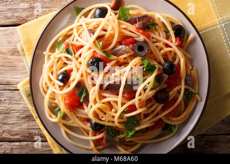 Pasta alla Puttanesca mit Sardellen und schwarzen Oliven auf einem Teller. horizontal oben Ansicht von oben Stockfoto