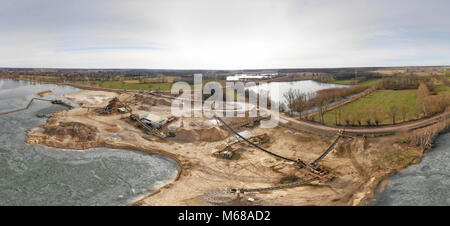 Composite Panorama von Luftaufnahmen und Luftaufnahmen von einem nassen Steinbruch für Kies und Sand mit einem Fast gefrorenen See und große maschinen für excav Stockfoto