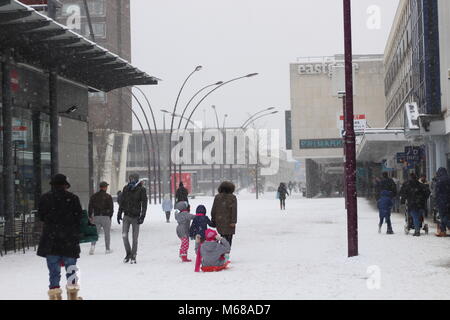 Shopper und Familien erwachen in einer verschneiten Landschaft, Basildon Town Square, Essex, Großbritannien. Stockfoto