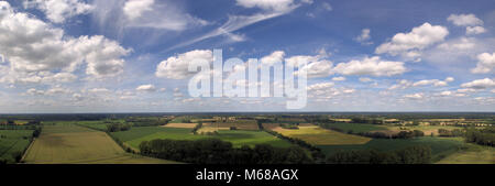 Composite Panorama mit Luftaufnahmen und Blick auf Wiesen, Felder, Ackerland und ein Himmel mit kleinen weißen Wolken, die mit Drone Stockfoto