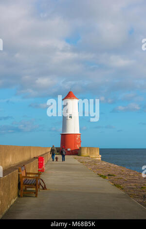 Leuchtturm UK, ein Paar mittleren Alters Ansatz der Leuchtturm am Ende der 880 Meter langen Mole Pier in Berwick upon Tweed, Northumberland, England. Stockfoto