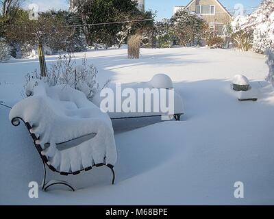 Das Tier aus dem Osten dumps Schnee auf einen Garten in Glasgow und macht den Garten Bank einen kühlen Ort zu sitzen. Stockfoto