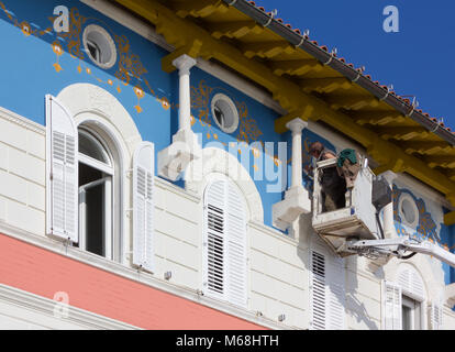 PIRAN, Slowenien, April 2013: Ein Handwerker Maler rundet die Dekoration der Fassade eines historischen Haus in der kleinen Stadt Piran, Slowenien Stockfoto