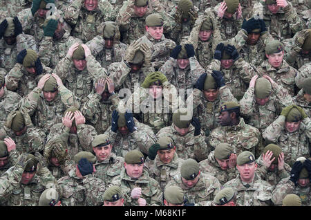 Mitglieder der 1.BATAILLON Welsh Guards ihre Barette für eine regimental Foto vor dem kombinierten St. David's Day Feier und Pre-Deployment Service in Elizabeth, Kasernen, Pirbright, Surrey arrangieren. Stockfoto