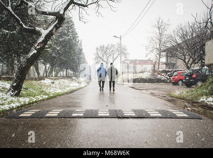 Zwei Jungs auf der Straße, während schneit Stockfoto