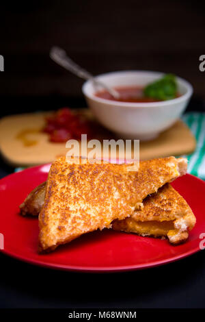 Klassische gegrillter Käse und Tomaten und Basilikum Suppe in einer dunklen Umgebung Stockfoto