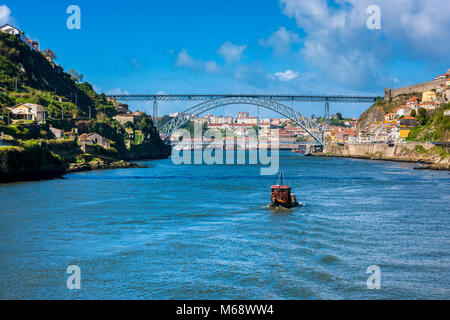 Rabelo Boot auf dem Fluss Douro nähert sich dem Dom Luis I Brücke in Porto, Portugal Stockfoto