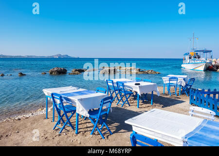 Strand mit traditionellen blauen Tischen und Stühlen. Kolymbia. Rhodos, Griechenland Stockfoto