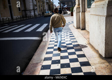 Ein Mann geht auf Sie Fliesen in Lissabon, Portugal. Stockfoto
