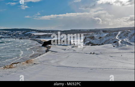 Küste von Moray in Schottland Cullen Bay mit STÜRMISCHEN MEER UND GOLFPLATZ ABGEDECKT IM WINTER SCHNEE Stockfoto