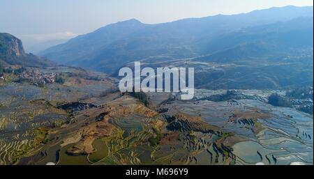 Reisfelder mit Wasser gefüllt, das Erstellen von atemberaubenden Mustern. Luftaufnahme auf die weltweit schönsten Reisterrassen, die yuanyang Hani Reisfelder. Stockfoto