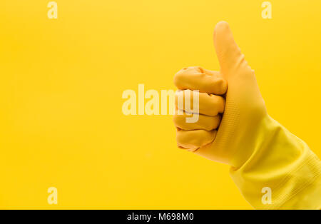 Daumen nach oben Geste mit der Hand in einem gelben Gummi Reinigung Handschuh aus Stockfoto
