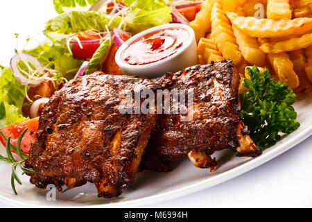 Gegrillte Rippchen, Pommes frites und Gemüse auf weißem Hintergrund Stockfoto