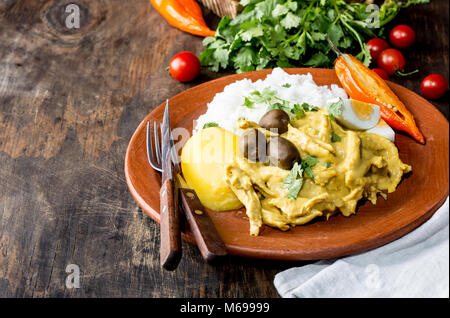 Mexikanischen und Peruanischen Küche. Aji de Gallina. Huhn aji de Gallina mit Oliven Ei und Reis auf Lehm Platte. Typisch peruanischen und mexikanischen Gericht. Stockfoto