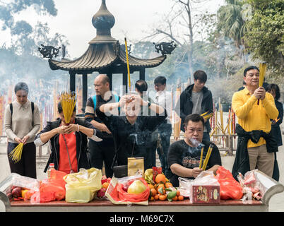 19. Februar 2018 - Ngong Ping, Lantau Island, Hong Kong. Asiaten an Po Lin Kloster beten mit brennenden joss Räucherstäbchen. Stockfoto