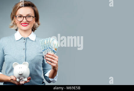 Frau mit Sparschwein und Bündel geld Banknoten. Finanzielle Einsparungen, intelligente Investition Konzept Stockfoto