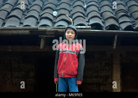 Ein junger einheimischer Ixil Maya Junge in der modernen Kleidung vor seinem Haus stehen. San Gaspar Chajul, Ixil Dreieck, Guatemala. Stockfoto