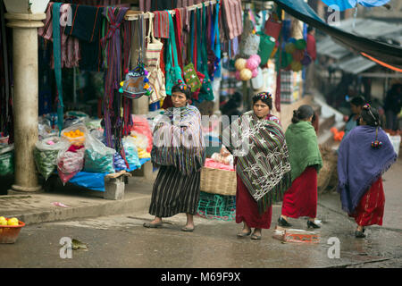 Zwei einheimische Ixil Maya Frauen in bunten Kleid zu Fuß durch den Markt in San Gaspar Chajul, Ixil Dreieck, Guatemala. Stockfoto