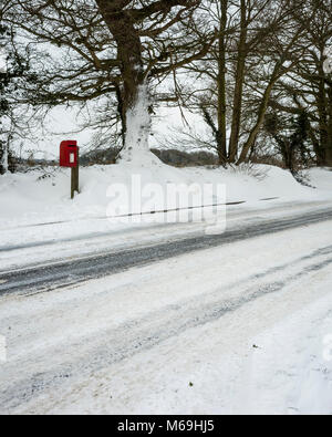 Ipswich, England. 1. März 2018. Eine abgeschiedene Royal Mail Briefkasten an der Seite der Schnee beladenen Road" das Tier aus dem Osten' Sturm. Schneeverwehungen haben völlig den Pfad bis zu der Straße blockiert, mit Schnee gebaut - bis über 30 cm hoch. Spuren von vorbeifahrenden Verkehr entlang der Straße gesehen werden kann. Mit einer Ricoh GRII Kamera fotografiert. Stockfoto