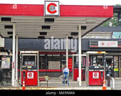 Anrufvermittlung an einer Tankstelle in Paterson, New Jersey, wartet auf Kunden. Die Gaspreise für einige Sorten sind unter $ 2,00 pro Gallone in 2015. Stockfoto