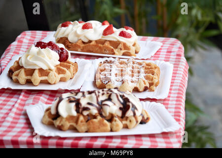 Beliebte Nationalgericht belgische Waffeln mit Erdbeeren, Kirschen, Schokolade und Pulver in der touristischen Stadt von Brügge. Stockfoto