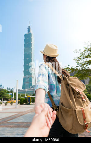 Ein paar der jungen asiatischen schönes Paar nimmt einen Spaziergang vor der Taipei höchste Gebäude. Hände halten zusammen nicht warten können, um ihre romantischen Jo zu starten Stockfoto