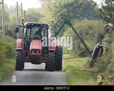 HEDGE TRIMMIMG MIT TRAKTOR ANGETRIEBEN TRIMMER IN LÄNDLICHEN LANE IN DER NÄHE VON STALHAM, Norfolk, England Großbritannien Stockfoto