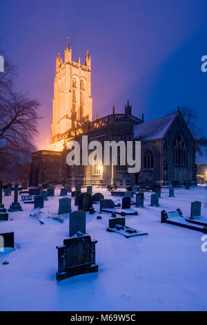 Das 15. Jahrhundert Allerheiligen Kirche im Dorf Wrington durch Schnee bei Dämmerung umgeben, North Somerset, England. Stockfoto