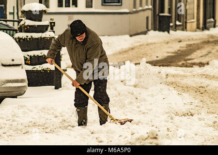 Leominster. 2 Mär, 2018. UK Wetter: ein Mann löscht Schnee mit einem Besen in Leominster als Sturm Emma verursacht eine Gelbe Wetterwarnung für Teile des Landes am 2. März 2018. Quelle: Jim Holz/Alamy leben Nachrichten Stockfoto