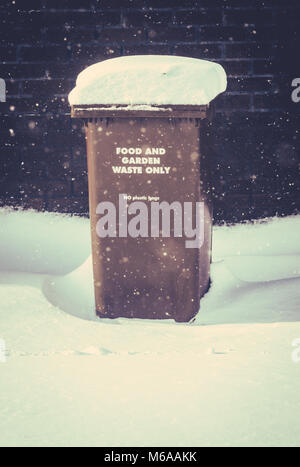 Schnee lag auf einem Recycling Mülltonne (Mülleimer) In Großbritannien während eines Schneesturms mit Kopie Raum Stockfoto