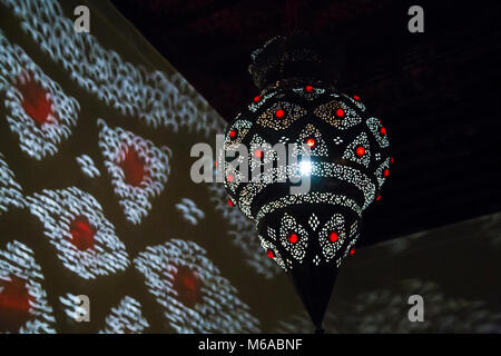 Orientalische marokkanische Lampe Casting Shadows auf eine Wand in einem Riad Stockfoto