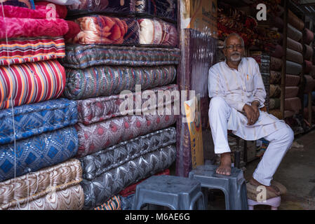 Eine Matratze Verkäufer vor seinem Geschäft in Varanasi, Indien sitzen. Stockfoto