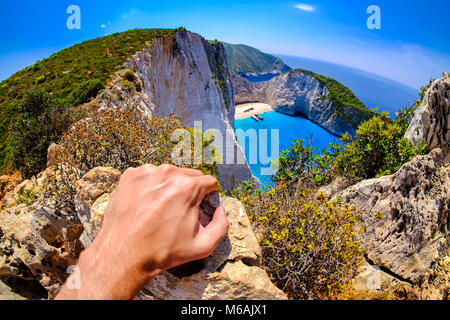 Touristische Blick auf navagio Schiffbruch Panoramablick auf die malerischen Blick Punkt der Insel Zakynthos Griechenland. Künstlerische Interpretation. Fokus auf der Hand. Stockfoto