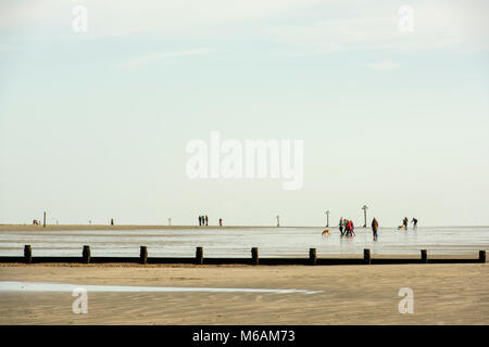 Menschen zu Fuß auf den Strand an der West Wittering, West Sussex, bei Ebbe auf einer schönen sonnigen Nachmittag. Stockfoto