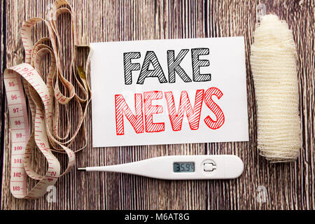 Handschriftlichen Text, gefälschte Nachrichten. Business Fitness Health Concept schreiben für Hoax Journalismus Geschrieben am Holz Hintergrund mit Bandage und die Stockfoto