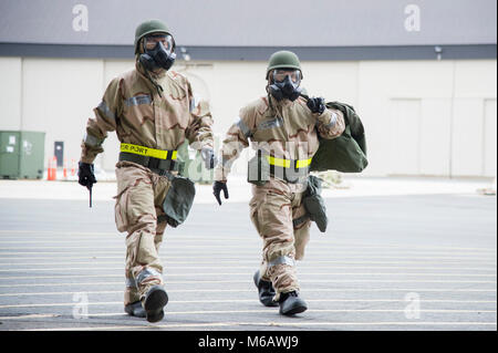 Team Dover Flieger bewegen zu einer gesicherten Position während des 2018 Vengeant Eagle Übung Feb.22, 2018 in Dover Air Force Base, Del die Ausübung enthalten eine simulierte Belastung durch einen atomaren, biologischen oder chemischen Kampfstoffen. (U.S. Air Force Stockfoto