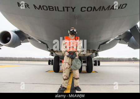 Airman 1st Class Jared Adams, 436Th Squadron Antenne Port cargo Prozessor, steht unter einem C-5 M Super Galaxy tragen volle MOPP gear während der 2018 Vengeant Eagle Übung Feb.22, 2018 in Dover Air Force Base, Del Adams das Flugzeug gemarshallt und dann beim Entladen der Fracht unterstützt. (U.S. Air Force Stockfoto